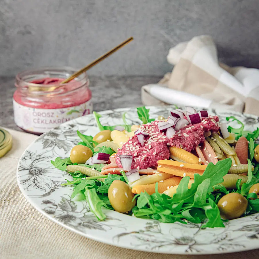 A héttárben felbontott orosz céklakrém láható a Lardershelf kínálatában. Előtte egy szépen megterített tál, amelyen rukkola, olajbogyó, felvágott lilahagyma és zöldséges olasz tészta látható. A tányéron fekete virágminták vannak.
