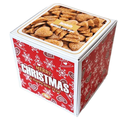 A képen a Sucrobello karácsonyi formacukra látható. A doboz színe piros és fehér. A matricán különböző karácsonyi minták (fenyőfa, hópihe, mézeskalács) láthatóak. 