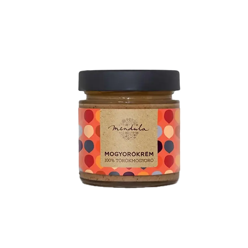 Mendula 100% törökmogyorókrém, az üvegben látszik a szépen elkészített mogyorókrém. A címkén piros, krém, kék és narancssárga pötyök láthatóak, a címke alapszíne a világos narancssárga. A kupak színe fekete. 